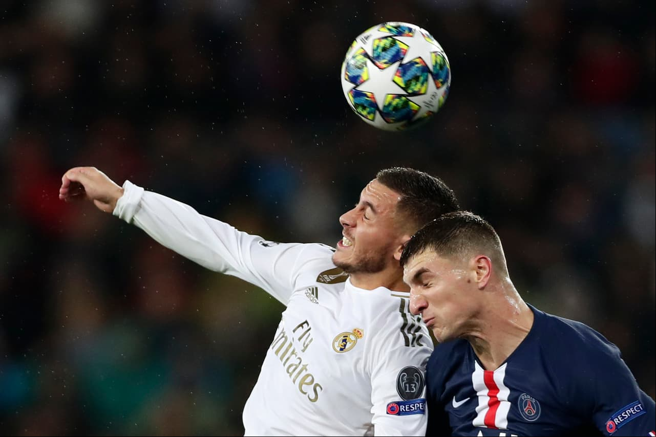 Luchando en el aire por el esférico, Thomas Meunier del PSG y Eden Hazard durante el encuentro de la Champions League.
