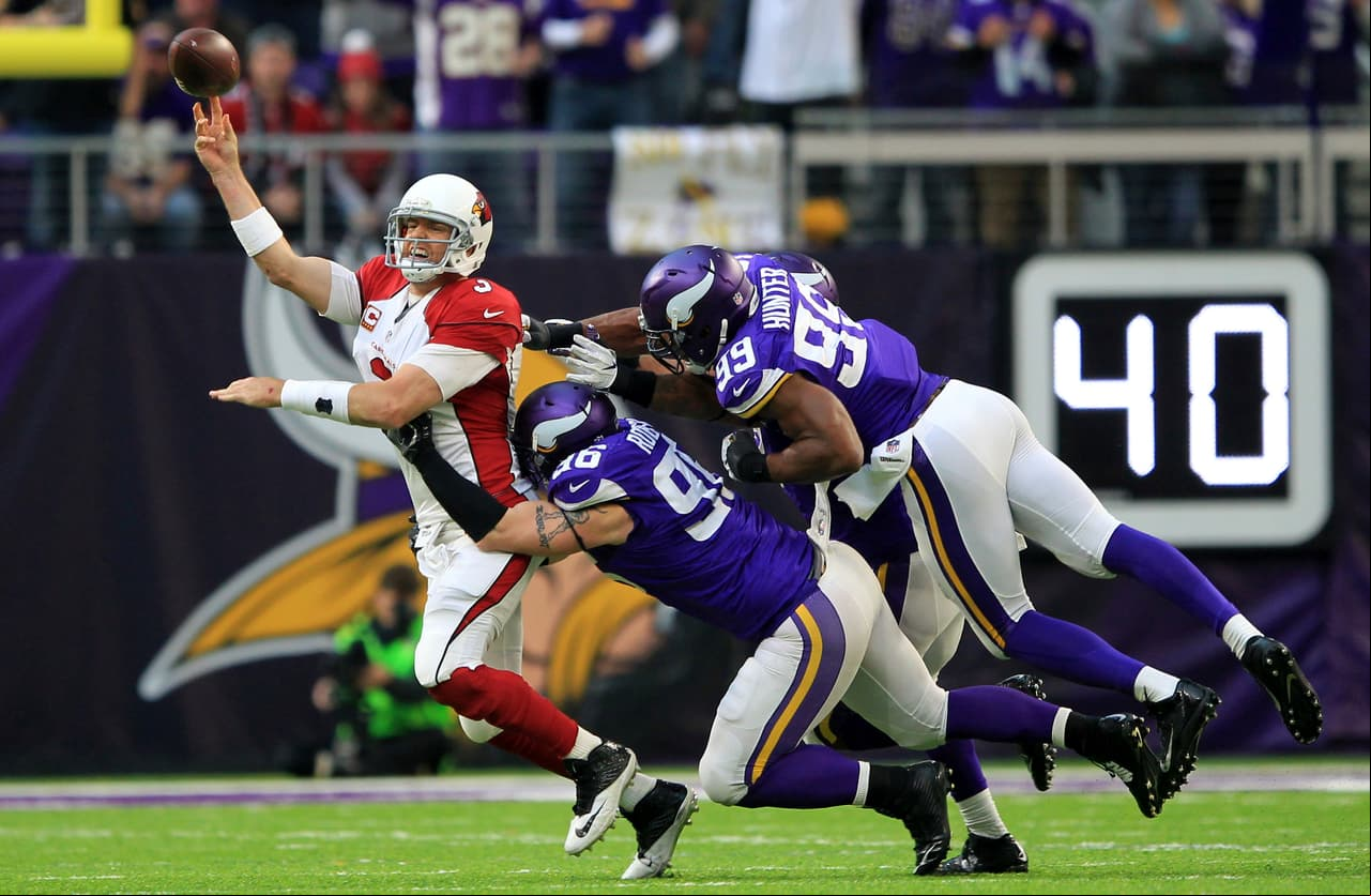 Arizona Cardinals quarterback Carson Palmer es while getting pressured by Minnesota Vikings defenders Brian Robison (96) and Danielle Hunter (99) during the second half of an NFL football game Sunday, Nov. 20, 2016, in Minneapolis. (AP Photo/Andy Clayton-King)