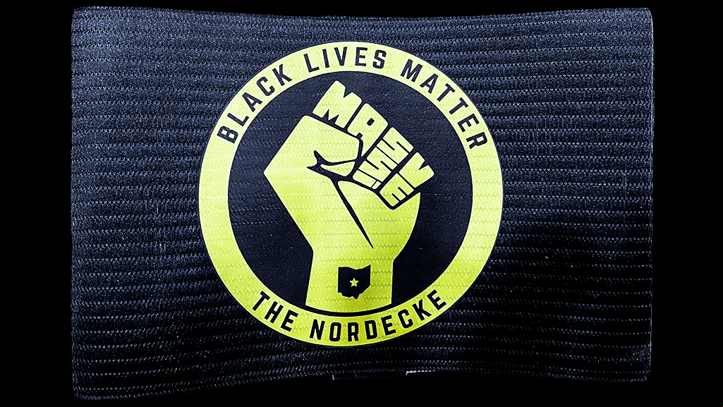 El brazalete de Columbus Crew SC fue diseñado de manera conjunta con el grupo de aficionados 'the Nordecke', con el objetivo de usar a la plataforma de los jugadores como una herramienta para educar y crear conciencia sobre la injusticia social y la falta de igualdad. El capitán Jonathan Mensah contó la historia detrás del brazalete en la web oficial de Columbus Crew SC.