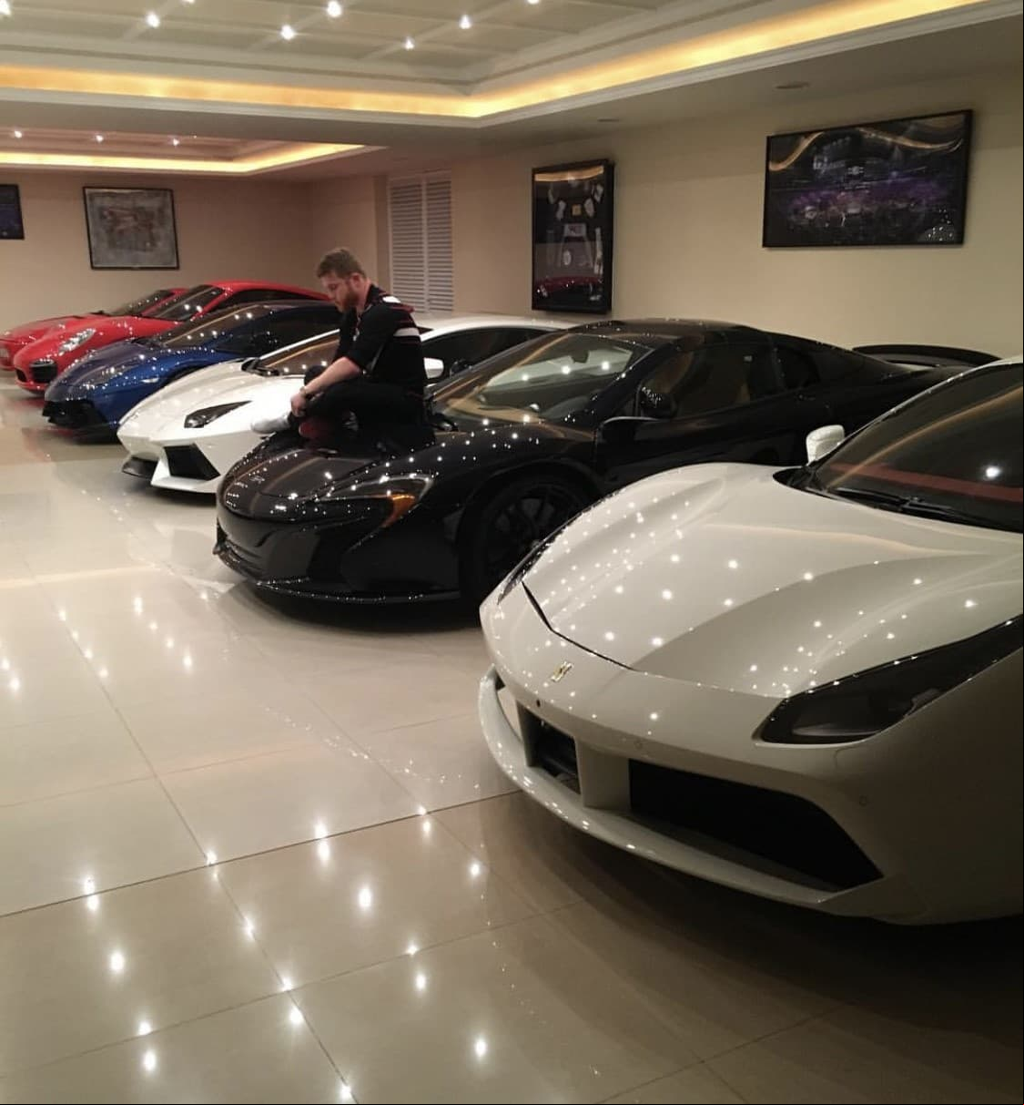 El canelo modela junto a una impresionante parte de su preciada colección de autos.